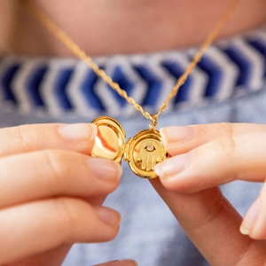 Vintage gouden ovale medaillon ketting met Hamsa hand en kristal aan een gedraaide ketting