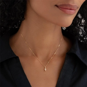 Detail van een marquise-geslepen kristallen hanger aan een vergulde stalen ketting