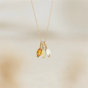 Detail macro-opname van drie marquise-stenen aan een goudkleurige roestvrijstalen ketting