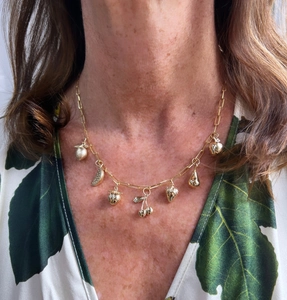Detail of 18K gold-plated paperclip necklace featuring 3D fruit pendants on a model