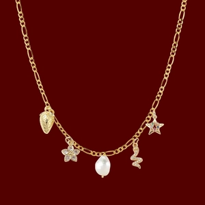 Gold Figaro necklace with charms including a strawberry, pearl, snake, and gemstone star