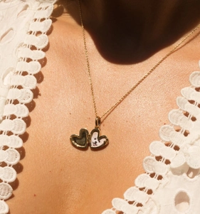 Primer plano de un relicario de corazón chapado en oro de 18K con una foto personalizada