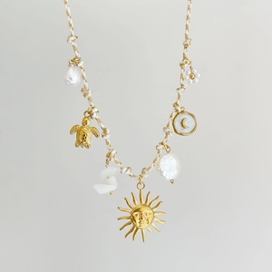 Bohemian woven rope necklace with gold sun, turtle, and pearl pendants for beach style