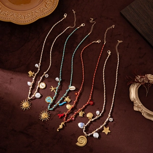 Detail of woven ocean necklaces with shell starfish pendants on vintage velvet background