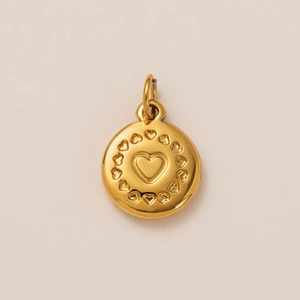 Detailed macro view of an 18K gold plated round pendant with embossed heart design