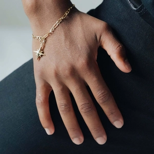 Detail of 18K gold plated octagonal star pendant on a dainty Figaro chain bracelet