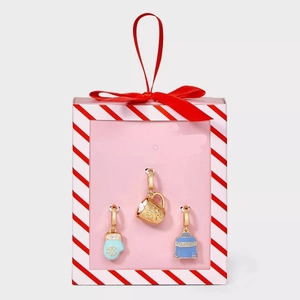 Close-up of winter charm set featuring blue sweater and glove in a festive gift box