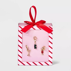 Close-up of enamel drink charms with 18K gold plating in a festive pink gift box