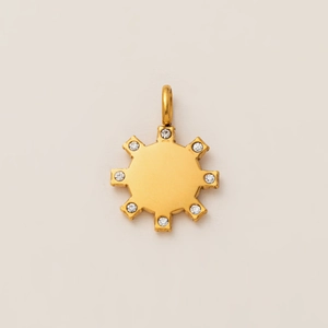 Détail d'un pendentif soleil plaqué or 18K avec huit pointes et pierres blanches