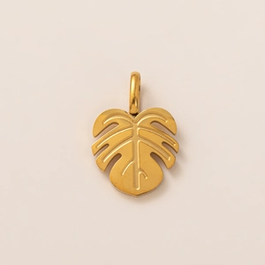 Detail view of a 18K gold monstera leaf pendant with polished metallic finish and bale