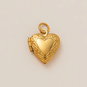 Détail d'un médaillon coeur en or 18K avec des bords gaufrés aux motifs floraux ciselés