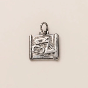 Detail of vintage silver London pendant with matte finish and engraved luggage tag design