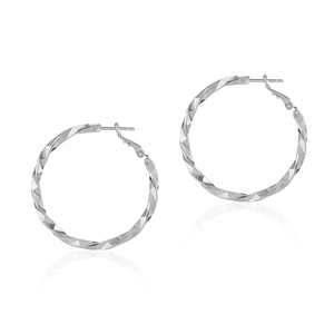 Close-up of geometric textured silver hoop earrings with diamond-cut metal facets