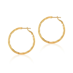 Detailed view of large gold hoop earrings with unique wave texture and polished finish