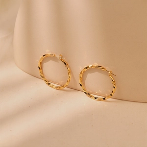 Detailed view of 18K gold plated hoop earrings with geometric multi-faceted cut surface