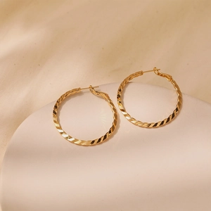 Macro shot of 18K gold-plated hoop earrings with twisted spiral texture and pins