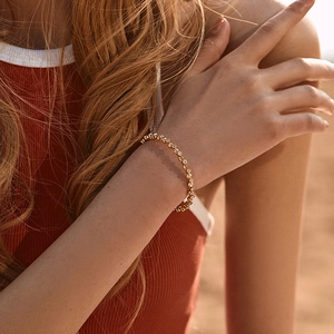 Detail of 18K gold-plated beaded bracelet with inlaid zircons on a model's wrist