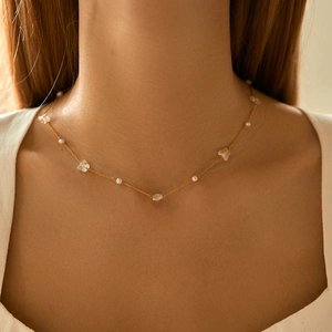 Collier bohème plaqué or 18 carats avec perles et papillons transparents sur un mannequin