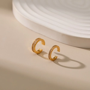Macro detail of 18K gold plated C-shaped ear cuffs with double row pave zircon inlay