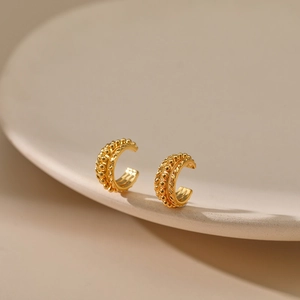 Detailed macro view of 18K gold plated brass ear cuff with bead and twisted texture details