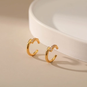 Detailed close-up of C-shaped 18K gold plated brass ear cuff with micro-set zircon stones