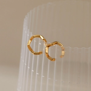 Detailed view of 18K gold plated C-shaped ear cuffs with irregular lava wave texture