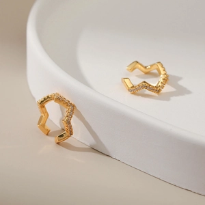 Detail of 18K gold plated wavy ear cuffs featuring micro-set sparkling cubic zirconia