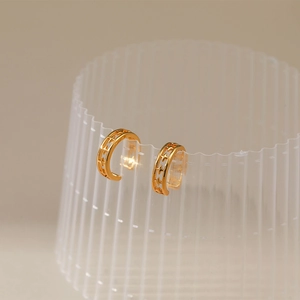 Detail view of 18K gold plated brass ear cuffs with hollow star patterns and zircon stones