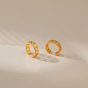 Macro detail of 18K gold plated brass ear cuffs featuring hollow star pattern and zircons