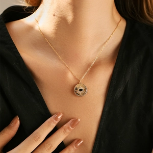 Collar de medalla dorada de estilo francés con colgante de ojo y circón en una modelo