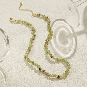 Macro detail van Boheemse kralenketting met groene natuurstenen en gouden karabijnsluiting