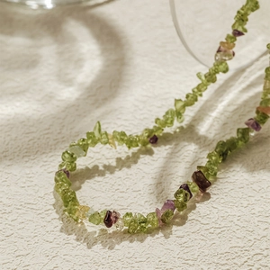 Macro detail van een boho kralenketting met natuurlijke toermalijn en turkoois