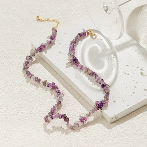 Detail van natuurlijke amethist ketting met gouden karabijnsluiting en verlengstuk