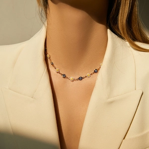 Bohemian 18K gold chain necklace with enamel daisies and evil eye beads on model
