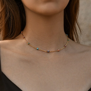 Detalle del collar choker de Ojo Turco colorido con tubos dorados en cuello de modelo