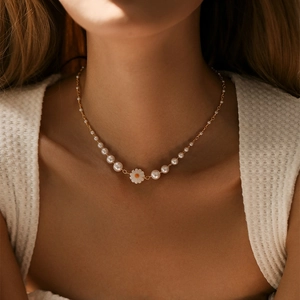 Primo piano di una collana di perle bohémien con ciondolo a margherita sul collo