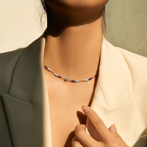 Handmade 18K gold-plated beaded necklace featuring evil eye pendant on model neck