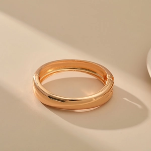 Polished gold bangle with minimalist sleek finish and a secure hinged clasp design
