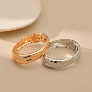 Polished gold and silver minimalist hinged bangles with center groove detail