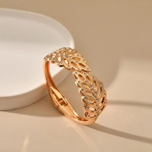 Detailed close-up of golden leaf bracelet with sparkling rhinestones and hinge detail
