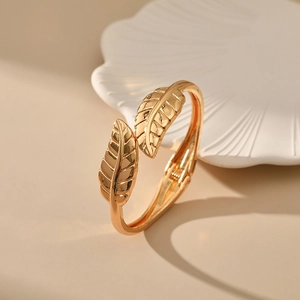 Close-up of golden irregular leaf bracelet with detailed veins and polished finish