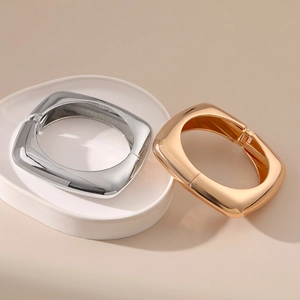 Close-up of minimalist gold and silver bangle bracelets with high-polish finish