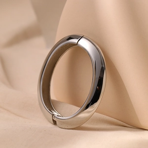 Close-up of a minimalist mirror-finish silver bangle with a hidden hinge closure