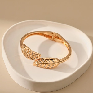 Detail of gold leaf bracelet with cubic zirconia paving and flexible spring hinge