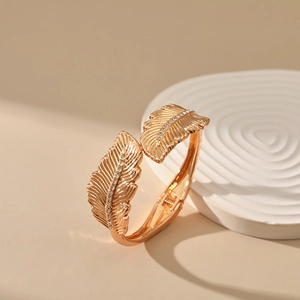 Detail of rose gold feather bangle featuring a hinged design and sparkling zircon accents