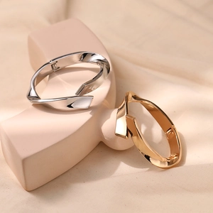 Minimalist irregular zinc alloy bangles with a polished mirror finish in gold and silver
