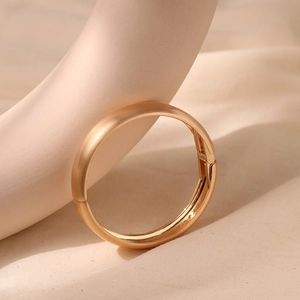 Detail of champagne gold bangle featuring a brushed exterior and mirrored inner surface