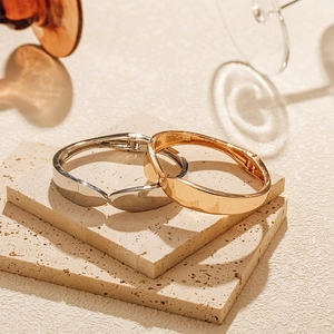Macro detail of polished gold and silver minimalist bangles on textured stone