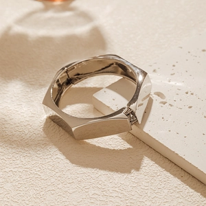 Detailed view of silver geometric faceted bangle with a polished mirror finish and hinge