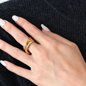 Bague multicouche en acier inoxydable doré portée sur la main avec pull noir en maille